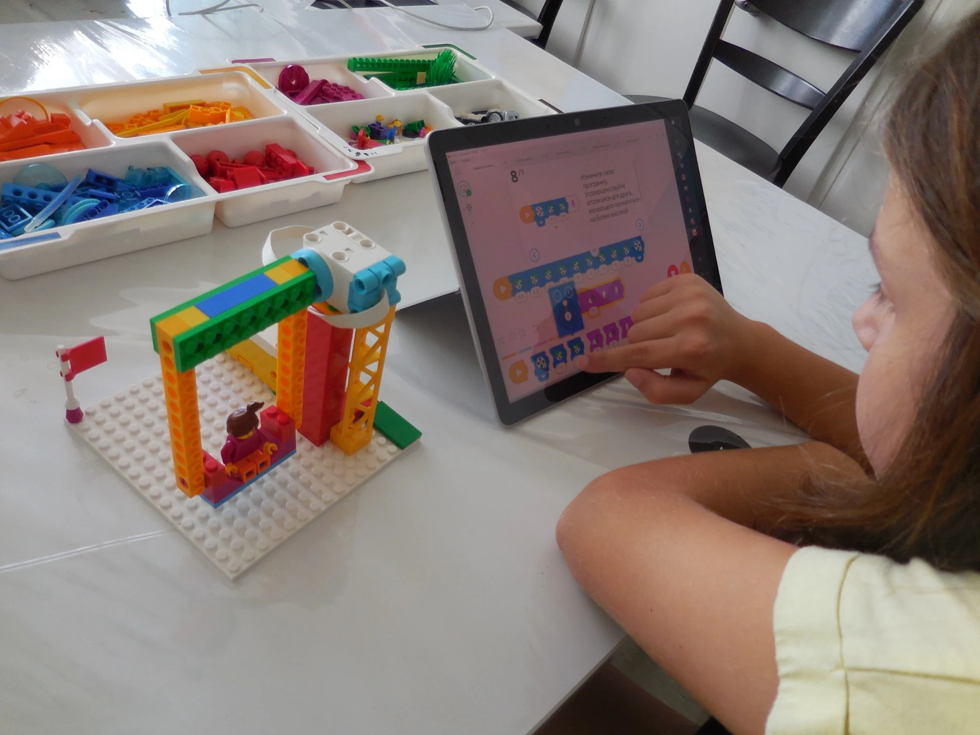 Kinder bauen Lego-Roboter und spielen Schach im Workshop